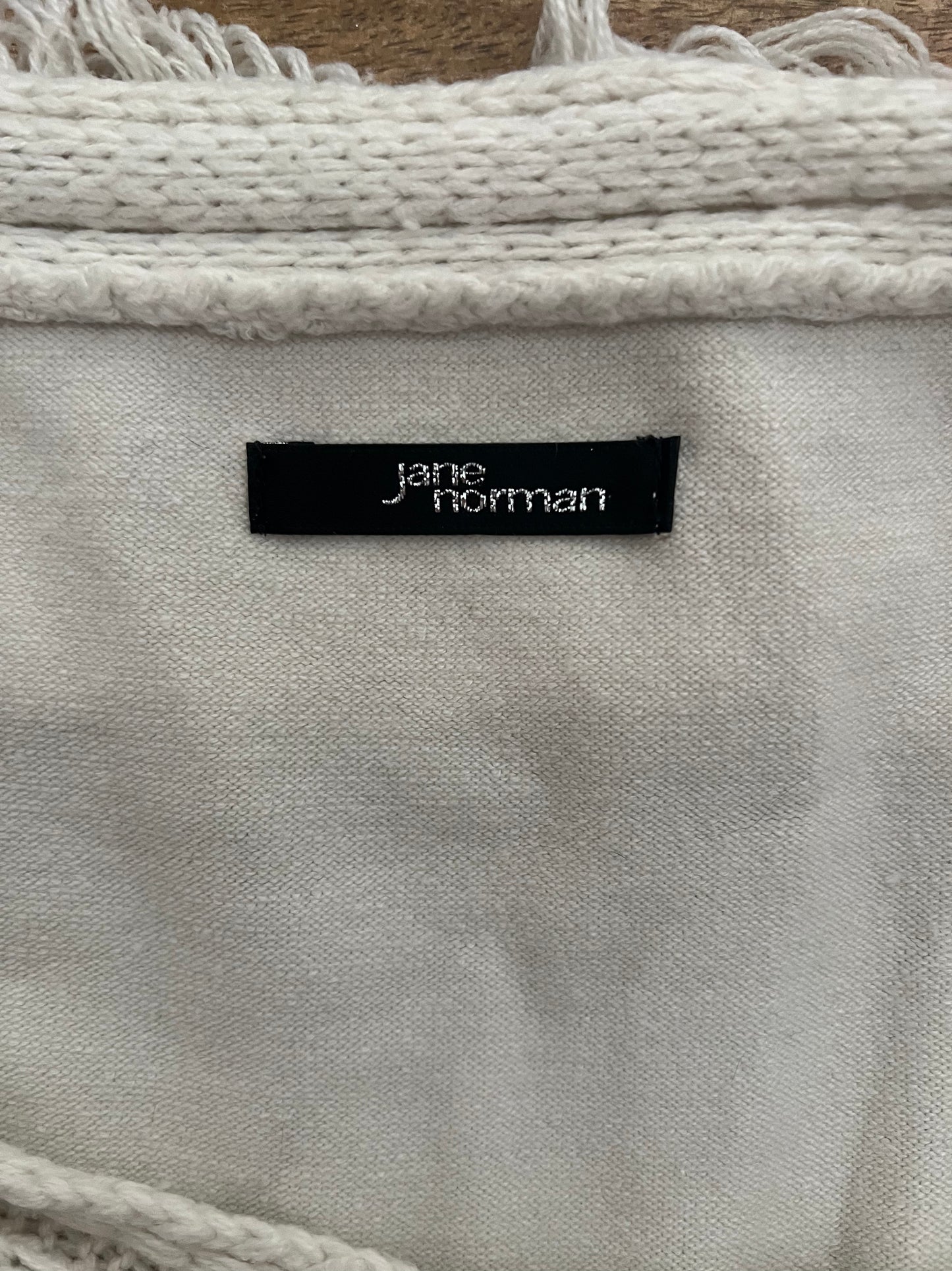 Close-up of a textured fabric with a 'jane norman' label.