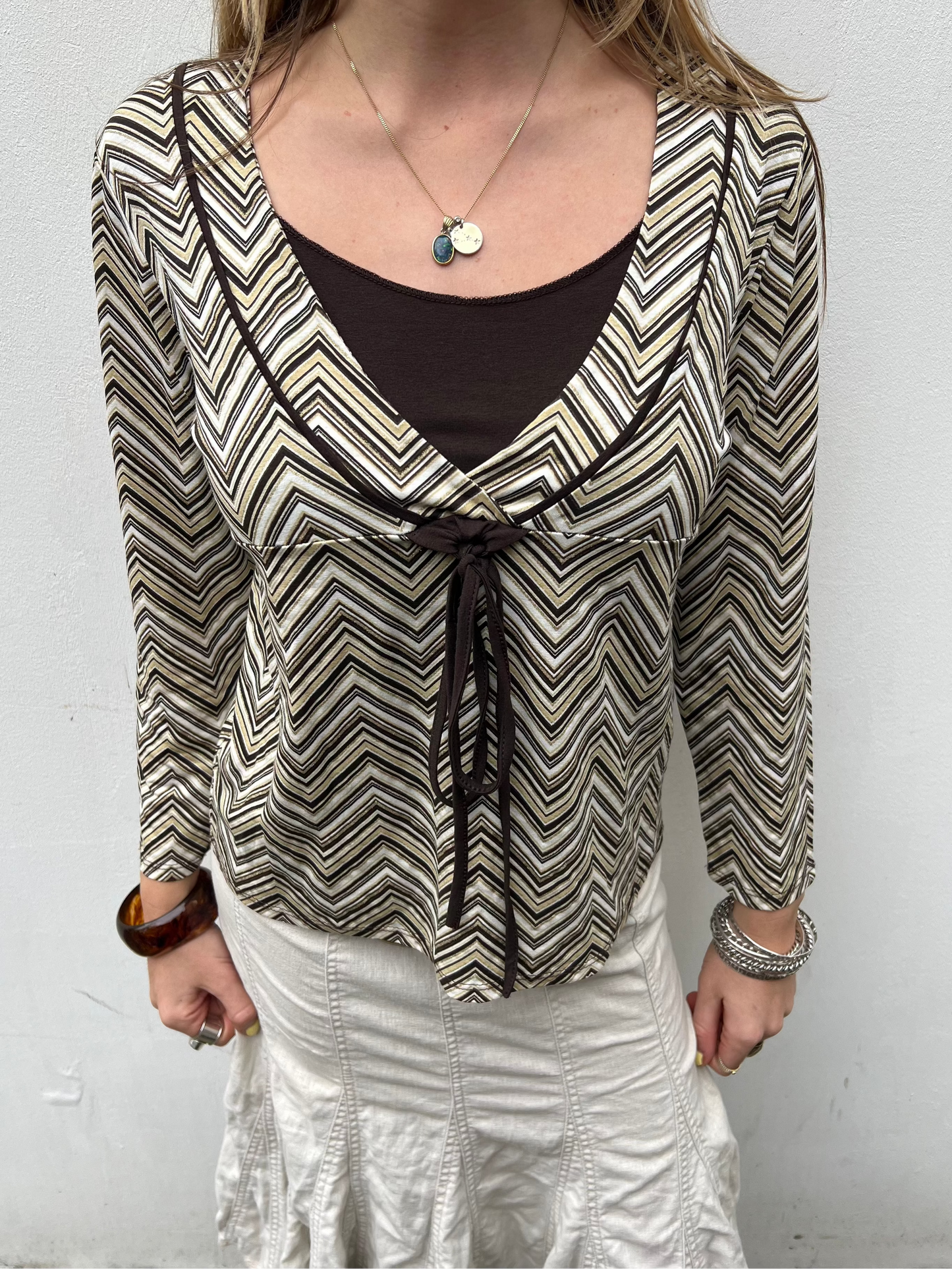 Person wearing a patterned blouse with a plain background