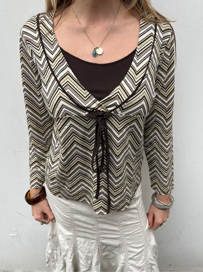 Person wearing a patterned blouse with a plain background