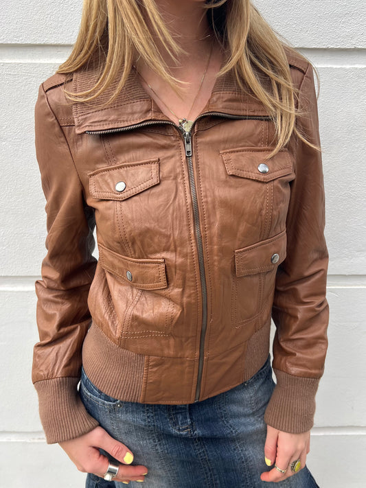 Brown leather jacket worn by a person against a light background