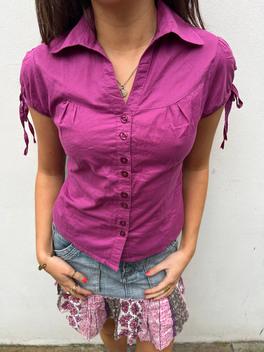 Person wearing a purple shirt with a white background