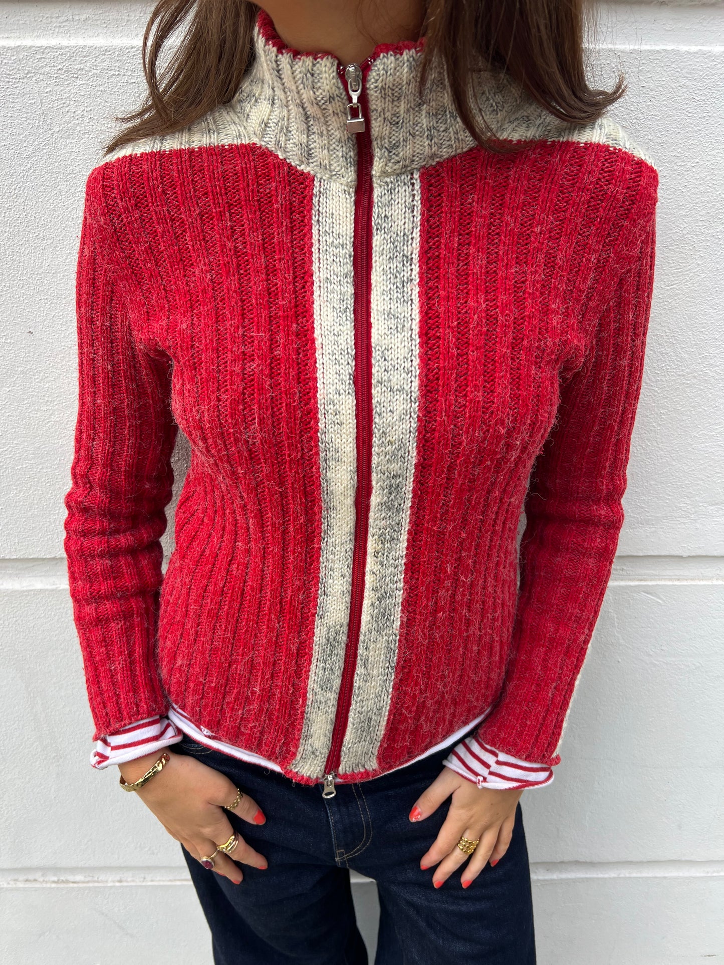 Red and gray zip-up sweater worn by a person against a white background