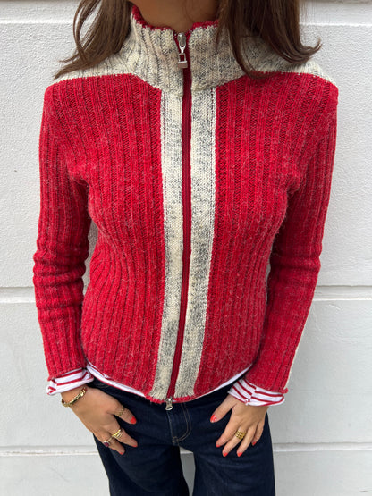 Red and gray zip-up sweater worn by a person against a white background